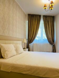 布加勒斯特Gloria’s Place的卧室配有一张大白色床和窗户