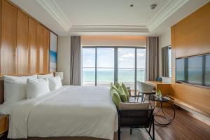 归仁Grand Hyams Hotel - Quy Nhon Beach的一间卧室设有一张大床和一个大窗户