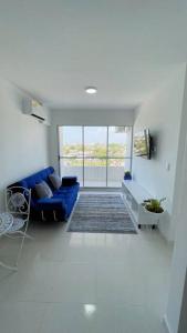 卡塔赫纳Apartamento muy cerca al Mar de 3 habitaciones的客厅设有蓝色的沙发和窗户。
