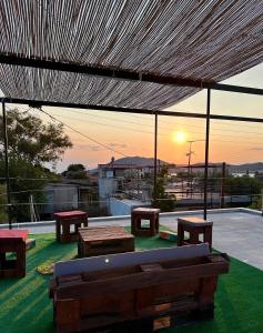 萨拉米斯Salamis Luxury Escape的一个带长椅并享有日落美景的庭院