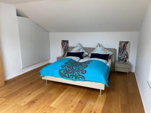 基姆高地区阿绍Alpenland Apartments的一间卧室配有一张带蓝色棉被的床