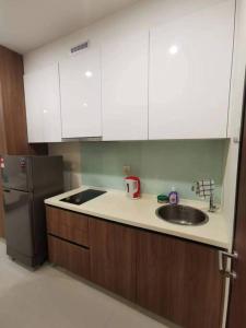 古晋Kuching Kozi Square Apartment (II)的厨房配有水槽和冰箱