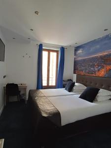 巴黎艾达玛莱酒店的一间卧室设有两张床,窗户配有蓝色窗帘