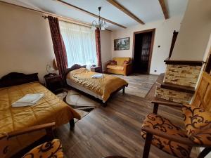 鲁恰内尼达GOŚCINIEC GŁODOWO的客厅设有两张床和壁炉