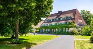 滕普林杜勒西-是弗黑德酒店的一座大房子,有树和路