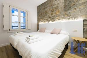 宏达瑞比亚Ubilla by Kaiberri Inmo的卧室设有一张白色大床和一扇窗户。