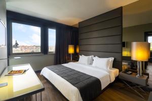 里斯本里斯本HF菲尼克斯酒店的酒店客房设有一张大床和窗户。
