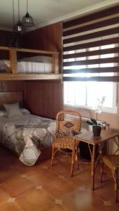 Las LaboresLOS ARCOS的卧室配有一张床和一张桌子及椅子
