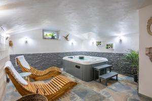 La Chambrele clos grillet的带浴缸和两把椅子的客房