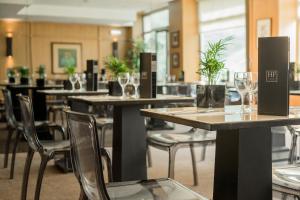 里斯本里斯本HF菲尼克斯酒店的配有桌椅和酒杯的餐厅