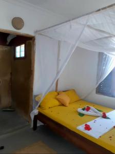 江比阿Mango Beach House的一间卧室配有一张带天蓬的黄色床
