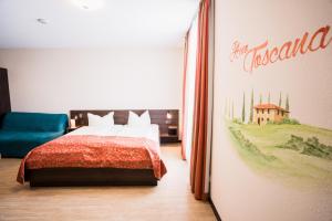 灵斯海姆Hotel La Toscana Nähe Europapark的卧室配有一张床,墙上挂有绘画作品