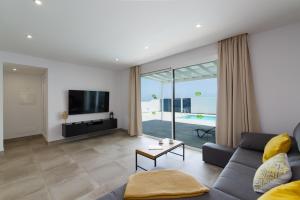 卡列罗港Ereza Villas Salitre的带沙发和电视的客厅