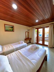帝力阿比如海滩度假酒店的配有木天花板的客房设有两张床。