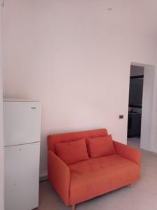 萨尔雷Apartamento Avenida的白色墙壁的房间里一张橙色的沙发