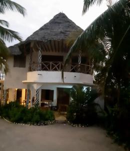 江比阿Mango Beach House的前面有棕榈树的房子