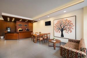 孟买Ginger Mumbai Andheri (MIDC)的酒店大堂设有桌子和墙上的树