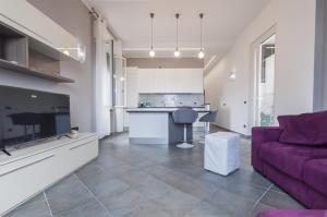 皮昂比诺The Breeze Way的一间带紫色沙发的客厅和一间厨房