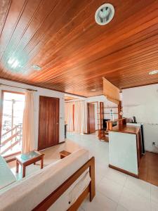 帝力阿比如海滩度假酒店的一间带木制天花板的客厅和一间厨房