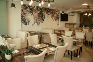 梅克内斯贝勒维Spa酒店的配有木桌和白色椅子的餐厅