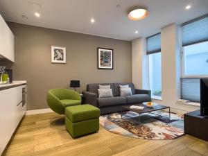 伦敦Mirabilis Apartments - Bayham Street的带沙发和绿色椅子的客厅