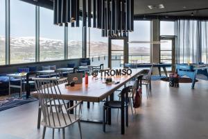 特罗姆瑟Moxy Tromso的餐厅设有桌椅和窗户。