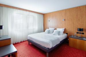 梅里尼亚克CERISE Bordeaux Mérignac Aéroport的酒店客房带一张大床,带白色床单