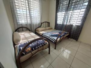 古达S99 HOMESTAY KUDAT的小房间设有两张床和两个窗户