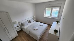塞尔察Hidden Sunset的一间白色的小卧室,配有床和窗户