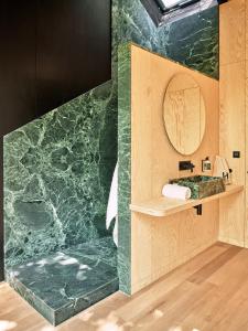 拉罗什-阿登Hutstuf The Eagle & Private Outdoor Spa的浴室设有绿色大理石墙和镜子