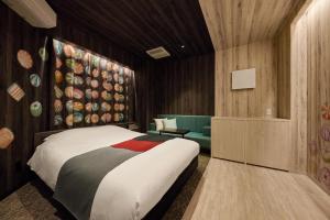 仙台ツルガナホテル-レジャーホテル-ラブホテル的一间卧室配有一张床和一张沙发