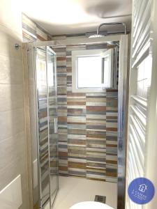 莫拉-迪巴里I CASERE D V'NGINZ - HOLIDAYS APARTMENTS的带淋浴的浴室和玻璃门