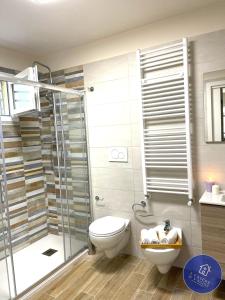 莫拉-迪巴里I CASERE D V'NGINZ - HOLIDAYS APARTMENTS的一间带卫生间和玻璃淋浴间的浴室