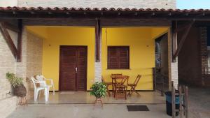雷东达Chalés Canto do Mar的天井上的黄色房屋,配有桌椅