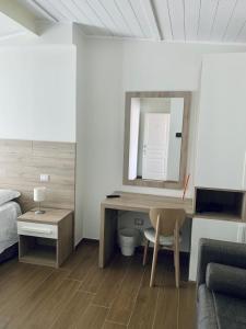San Costantino AlbaneseTempio Aurora的一间卧室配有书桌、一张床和镜子