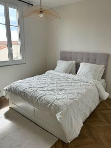 戛纳Maison de Ville Cannes Centre的白色卧室内的一张白色床,设有窗户