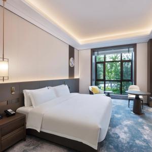 保定雄安朗悦voco酒店的卧室设有一张白色大床和一扇窗户。