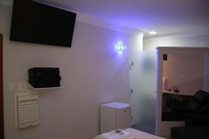 费尔南多波利斯SAFIRA MOTEL II的一间设有壁挂式电视和冰箱的客房