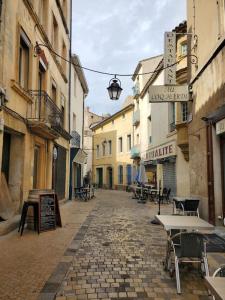 纳博讷La Louve - maison de ville的街上一条带桌椅的小巷