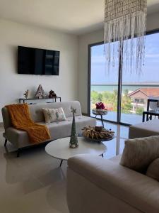 La SiriacaApartamento con vista al mar en condominio de lujo的带沙发和吊灯的客厅