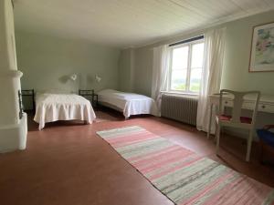 阿尔沃斯塔Gåvetorps Gård的客房设有两张床和大窗户。