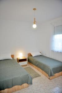 法里拉基J&M FALIRAKI的一间卧室设有两张床和窗户。