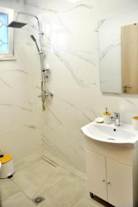 法里拉基J&M FALIRAKI的白色的浴室设有水槽和淋浴。