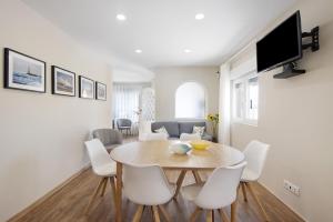 ArcozeloPontes Guest House的一间带桌子和白色椅子的用餐室