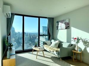 墨尔本Sweet Home Apartment Melbourne CBD的带沙发和大窗户的客厅