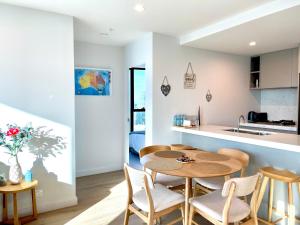 墨尔本Sweet Home Apartment Melbourne CBD的厨房以及带桌椅的用餐室。