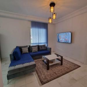 艾尔亚奈City View, Ennasr Spacious s2 Apartment的客厅配有蓝色的沙发和桌子