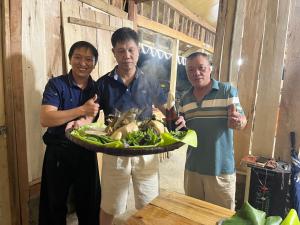 木州县Hoa Phong homestay Moc Chau的一群人拿着一盘食物