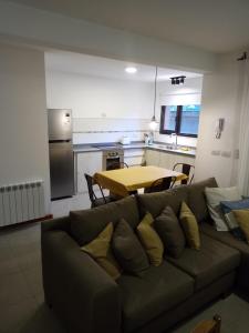 圣马丁德洛斯Hermoso Departamento Céntrico en San Martin de los Andes的客厅配有沙发和餐桌,厨房配有桌子