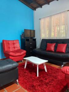 圣希尔Finca el Paraíso的客厅配有红色和黑色的家具和茶几